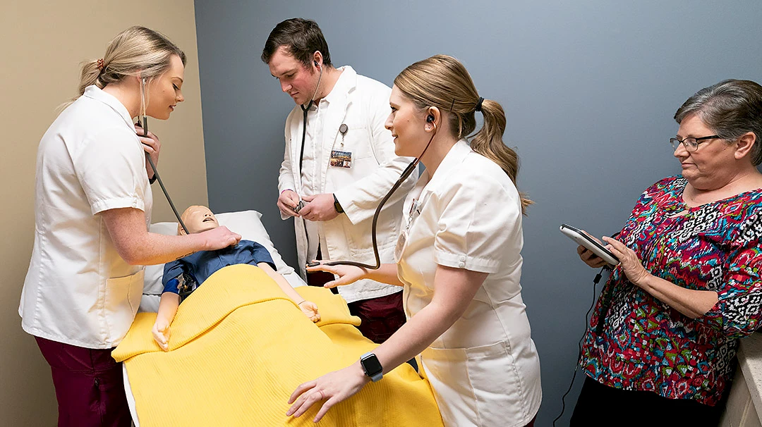 Henderson nursing students get their first hands-on experience with "SimJunior" simulator.